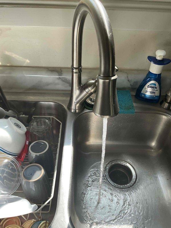 Responded to kitchen faucet low water pressure complaint ongoing for several weeks in 1961-built home. Diagnosed and removed clogged faucet aerator assembly, which contained mineral buildup and debris restricting water flow. Cleaned aerator components, reassembled, and tested faucet operation to confirm full water pressure restored to normal levels.