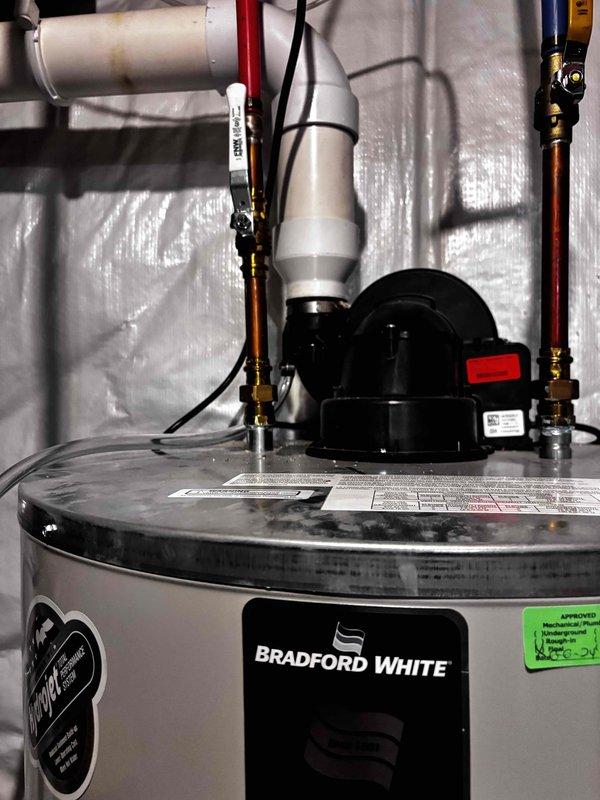 Installed condensate drain tube on Bradford White water heater at no charge to address calcification issues caused by condensation from previously extended venting line. The installation was completed as a courtesy follow-up to resolve moisture-related problems that developed after the initial water heater installation and vent modification work.