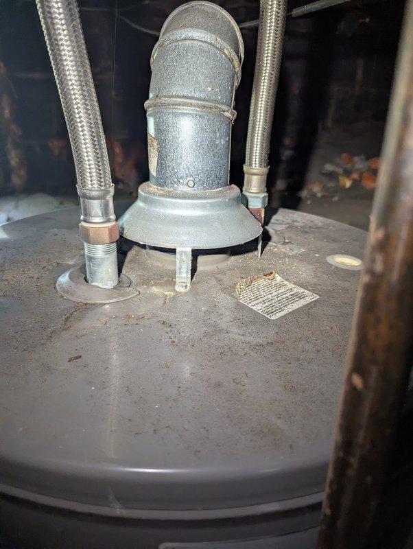 # Water Heater Code Compliance Inspection

Responded to scheduled appointment for water heater evaluation. Upon arrival, inspected 9-year-old Rheem residential water heater and identified multiple code violations requiring customer attention. Primary issues included improper installation of temperature and pressure relief valve discharge piping, inadequate clearances, and non-compliant venting configuration. 

Documented existing conditions with detailed photographs showing top-mounted connection assembly, corroded piping components, and overall installation deficiencies. Flexible supply line connections showed signs of age and potential future failure points. Provided customer with comprehensive assessment of required corrections to bring unit into compliance with current plumbing codes and manufacturer specifications. Advised customer of safety concerns and recommended scheduling follow-up service to address identified deficiencies. Customer was walked out with explanation of finding