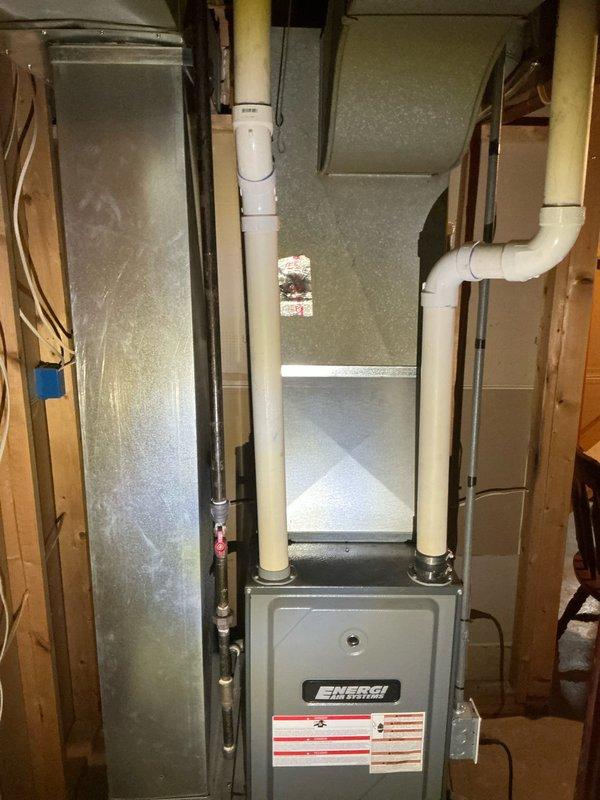 Performed comprehensive evaluation of residential property for air conditioning system installation. Home currently equipped with existing furnace unit installed approximately 15 years ago but has never had central air conditioning. Assessed basement utility area containing gray metal furnace with white PVC venting system and metal ductwork configuration. Documented existing HVAC infrastructure including furnace placement, ventilation routing, available space for condenser unit installation, and electrical service capacity. Evaluated ductwork compatibility for AC integration and determined optimal equipment placement within unfinished basement area with concrete block walls and exposed framing. Provided detailed estimate for complete air conditioning system installation to work in conjunction with existing heating equipment.