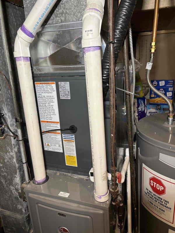 Completed full air conditioning system installation including outdoor condensing unit and indoor evaporator coil integration with existing furnace. Installed and connected copper refrigerant lines with proper insulation, established electrical connections, and integrated new AC components with current heating system. Charged system with refrigerant, verified proper operation of all components, and confirmed airflow through existing ductwork. Tested system performance with temperature differential readings showing 107°F and 104°F at service ports, indicating proper refrigerant charge and system operation. Installed required venting modifications using PVC piping for condensate drainage and secured all connections per manufacturer specifications. System operational and performing within normal parameters upon completion.
