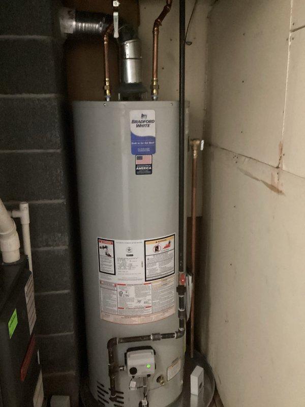 Removed and disposed of existing water heater unit. Installed new 40-gallon tall Bradford White water heater with proper copper piping connections and brass fittings. Installed 4-inch chimney liner for proper venting of combustion gases. All connections tested and verified operational, with 6-year parts warranty and 1-year labor warranty provided on installation.