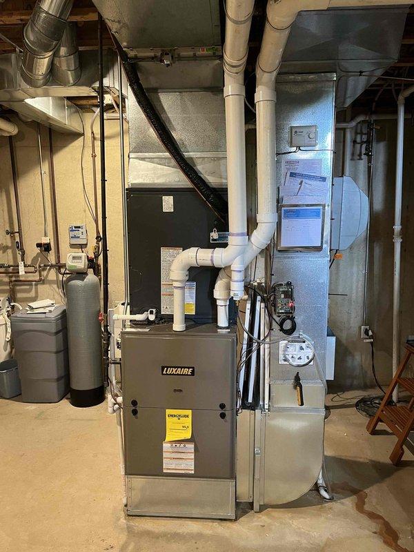 Completed full air conditioning system replacement at residential property. Installed new outdoor condensing unit on existing concrete pad with proper clearances from exterior wall, secured all refrigerant line connections, and verified electrical connections to outdoor unit. Interior installation included new air handler equipment integrated with existing Luxaire furnace system in basement mechanical room, with all refrigerant lines, condensate drainage, and PVC venting properly routed and secured. System was pressure tested for leaks, evacuated, charged to manufacturer specifications, and tested through complete cooling cycle to verify proper operation of all components.