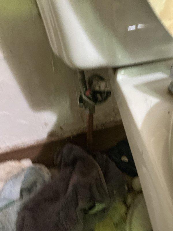Responded to water leak in basement originating from toilet supply line on upper floor. Upon inspection, identified failed water supply line connection at toilet fixture with visible water damage and staining around base. Investigation of basement area revealed severely corroded metal piping in the plumbing system beneath the structure, with active water intrusion from the compromised supply line above. Shut off water supply, replaced defective supply line and connection hardware at toilet fixture, verified proper installation and tested system for leaks. Confirmed no additional water flow to basement area and advised property owner of the deteriorated condition of older metal piping observed in crawl space that may require future attention.