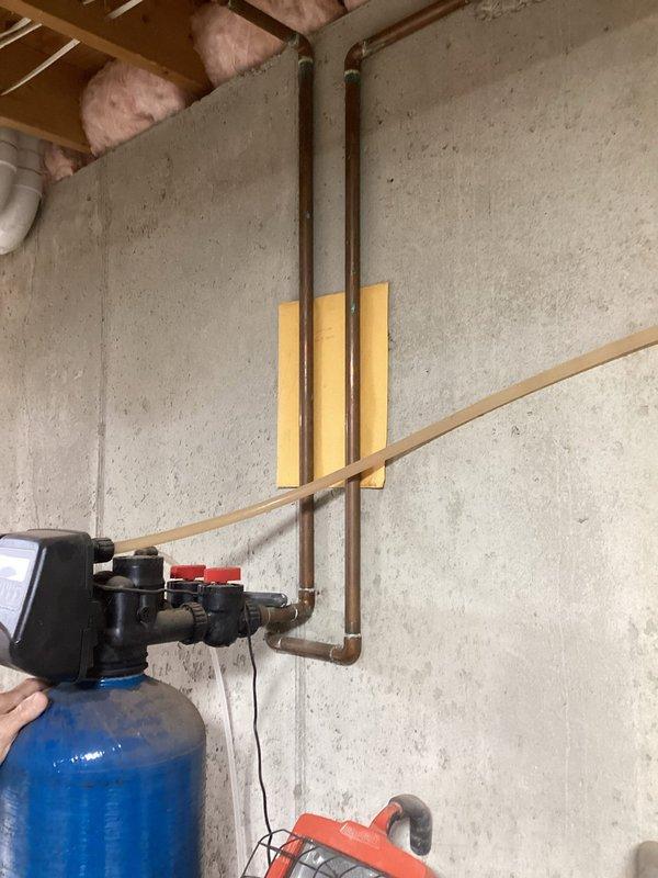Conducted on-site evaluation of residential plumbing system to assess feasibility and requirements for whole house PFAS filtration system installation. Inspected existing water distribution infrastructure including main supply lines, pressure tank, water heater, and copper piping configuration in basement mechanical space. Documented current system layout, pipe routing, available installation space, and electrical accessibility to determine optimal placement for comprehensive PFAS removal equipment. Photographed existing pressure tank assembly, valve locations, and water heater connections to develop accurate proposal for whole house filtration solution addressing PFAS contamination concerns.