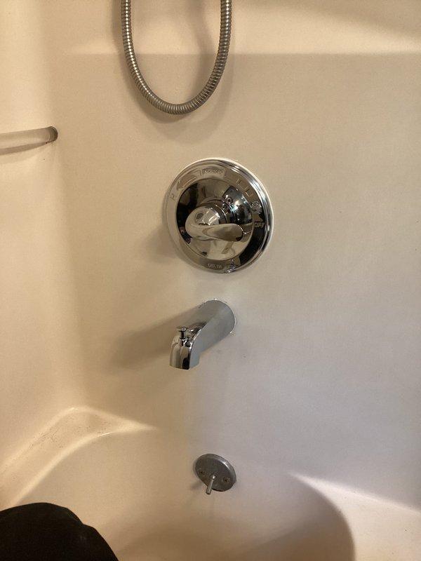 Replaced defective shower valve assembly in bathroom tub/shower combination. Accessed plumbing connections through wall opening, removed old valve, installed new chrome shower valve with temperature control and repair plate to cover existing wall opening. Reconnected water supply lines to new valve assembly, tested for proper operation and verified no leaks. Completed work with all fixtures functioning correctly.