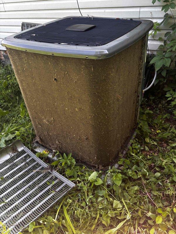 Completed annual cooling maintenance on EnergiAir system under warranty coverage. Upon arrival, found outdoor condenser unit in severely neglected condition with heavy accumulation of dirt, grime, organic growth, and mildew covering exterior surfaces. Side access panel was detached and lying on ground in vegetation. Unit exhibited extensive soiling on front-facing coil panel with thick grayish-brown debris buildup and streaking patterns indicating prolonged exposure without maintenance.

Performed comprehensive cleaning of condenser coils and exterior cabinet. Removed heavy debris accumulation from base and surrounding area. Reinstalled loose side panel. Inspected cooling fins and noted white residue along top protective cover edge. Completed standard tune-up procedures including electrical connection inspection, refrigerant level verification, and operational testing. System restored to proper working condition. Documented pre-service condition with photographs. Recommended increased 