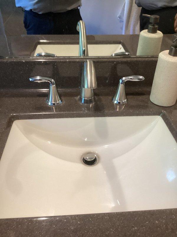 Performed comprehensive plumbing system evaluation addressing multiple concerns. Inspected reverse osmosis filtration system under kitchen sink, verified filter condition and system operation. Serviced bathroom faucet with stiff handles, disassembled three-piece chrome faucet assembly on undermount vanity sink to address difficult operation of hot and cold water controls. Consulted with homeowner regarding septic backup system options and recommendations for property protection.