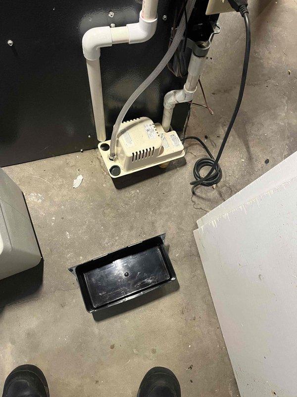 Completed annual cooling system maintenance and inspection. Verified proper operation of condensate pump and drainage system, confirmed all PVC connections are secure and functioning correctly. Inspected drain pan for proper placement and condition, documented equipment status with photos showing condensate management components operating as designed.