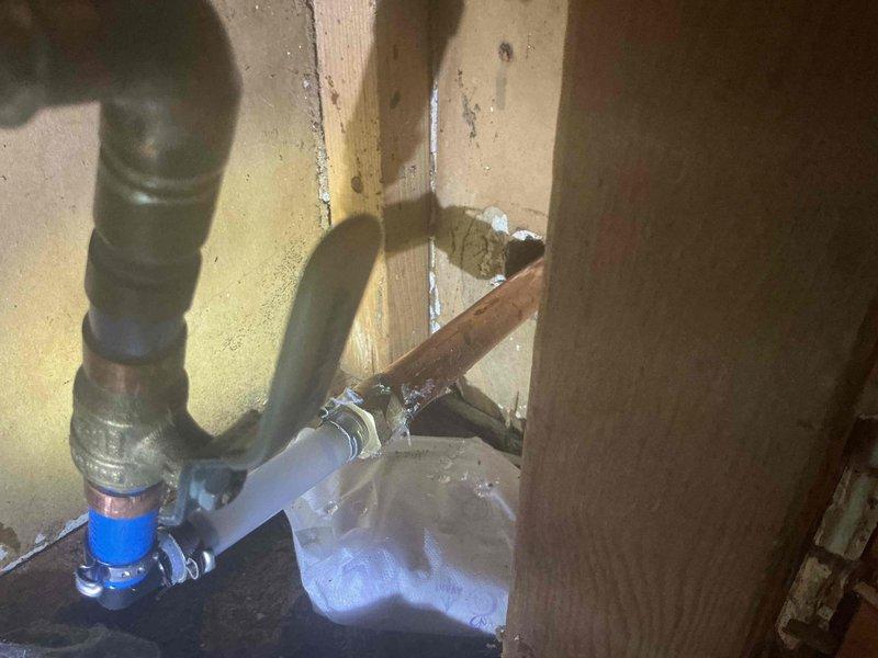 Responded to recurring failure of exterior spigot supply line. Upon inspection, discovered deteriorated connection between galvanized supply piping and outdoor faucet assembly in crawl space beneath structure. Replaced failed section with new PVC piping, installed quarter-turn ball valve shutoff for future maintenance access, and secured proper connections using threaded metal fittings to transition between existing galvanized pipe and new blue PVC supply line. All connections tested and verified leak-free under pressure.