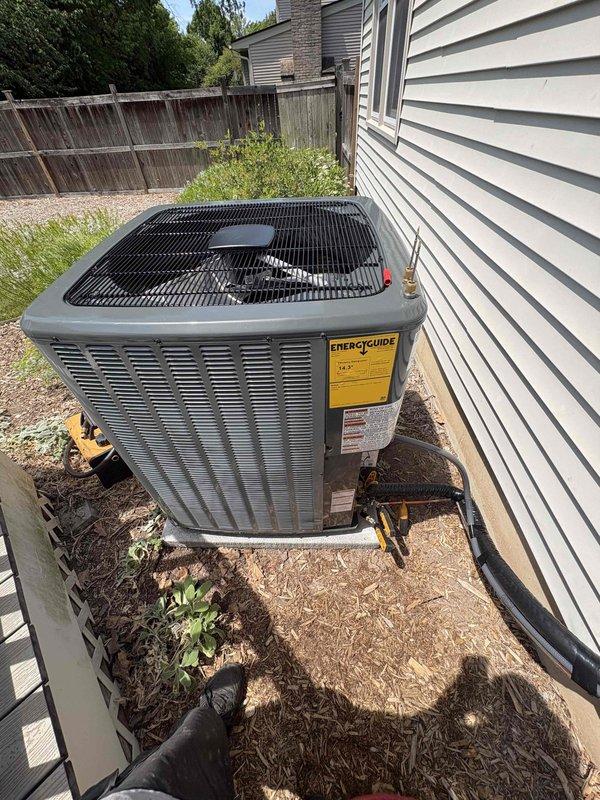 Completed full HVAC system installation including new furnace and air conditioning condenser unit. Installed outdoor condensing unit on concrete pad with proper refrigerant line connections, electrical conduit routing, and service valve installation. All refrigerant lines properly insulated and secured to building exterior, with system positioned for optimal airflow and serviceability. Unit installation meets manufacturer specifications with all required labels and energy efficiency documentation in place.
