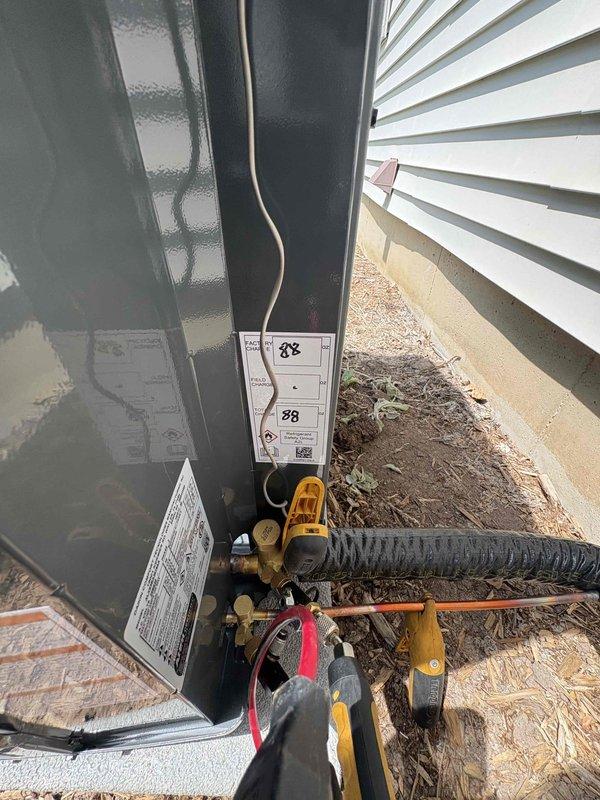 Completed full HVAC system installation including new furnace and air conditioning condenser unit. Installed outdoor condensing unit on concrete pad with proper refrigerant line connections, electrical conduit routing, and service valve installation. All refrigerant lines properly insulated and secured to building exterior, with system positioned for optimal airflow and serviceability. Unit installation meets manufacturer specifications with all required labels and energy efficiency documentation in place.