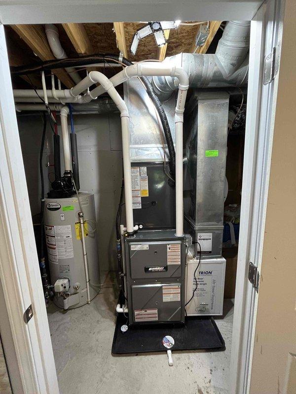 Completed full installation of new residential furnace and air conditioning system in mechanical room. Installed vertical furnace unit with proper venting using white PVC piping, connected metallic ductwork with flexible transitions, and integrated drainage systems. Mounted and connected AC air handler with humidification equipment. All electrical connections, gas lines, and condensate drainage properly installed per manufacturer specifications. System tested and verified operational, with all safety labels and technical specifications properly displayed on equipment.