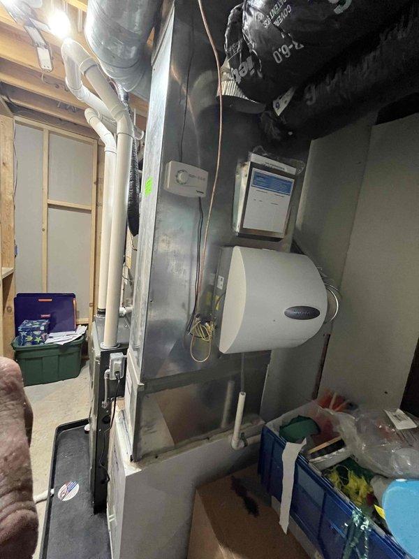 Completed full installation of new residential furnace and air conditioning system in mechanical room. Installed vertical furnace unit with proper venting using white PVC piping, connected metallic ductwork with flexible transitions, and integrated drainage systems. Mounted and connected AC air handler with humidification equipment. All electrical connections, gas lines, and condensate drainage properly installed per manufacturer specifications. System tested and verified operational, with all safety labels and technical specifications properly displayed on equipment.