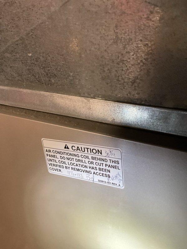 Responded to cooling complaint on 16-year-old Carrier system with inadequate cooling performance. Inspected indoor air handler unit located in basement utility area and verified system operation. Customer suspected low refrigerant charge as cause of reduced cooling capacity. Performed visual inspection of evaporator coil access panel and documented equipment condition with photos for service records.