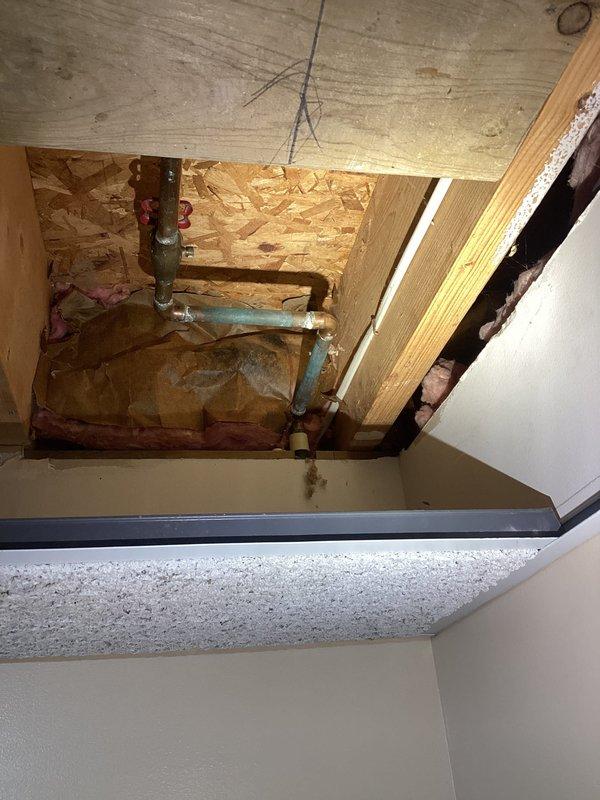 Responded to service call for leaking outdoor water spigot at residential property. Upon inspection, accessed plumbing system through ceiling cavity to locate source of leak at copper pipe connection serving exterior hose bib. Repaired faulty valve connection with oxidized copper piping, replaced worn components, and verified system integrity. Created access opening in wall/ceiling to reach affected plumbing, completed repairs, and confirmed no active leaks present upon completion.