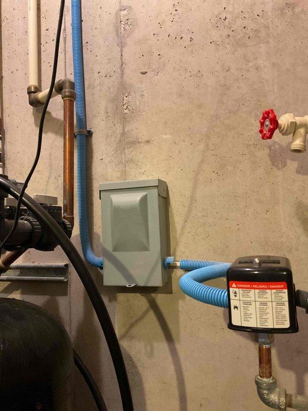 Completed well pressure tank replacement in residential utility space. Removed existing failed pressure tank and installed new blue cylindrical pressure tank with electronic pressure control system, including all necessary connections to existing copper supply lines, pressure gauge, shut-off valves, and electrical components. System tested and verified operational with proper pressure settings confirmed.