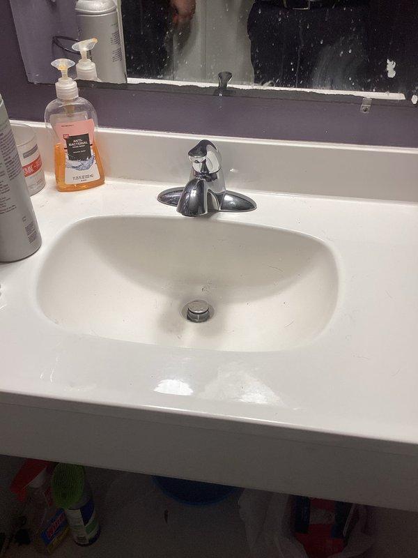 Responded to multiple plumbing concerns in a 35-year-old residential property. Addressed basement bathroom faucet leak by inspecting undermount sink with chrome single-handle faucet and examining cabinet plumbing connections including P-trap assembly, supply lines, and shut-off valves. Verified proper drainage function and checked for any additional leaks in the vanity plumbing system. All fixtures photographed and documented for service records.