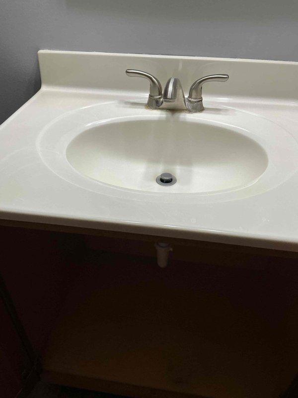 Successfully replaced three customer-supplied faucets in two bathrooms and installed a new customer-supplied toilet seat. Addressed slow drain issue in one bathroom that had been an ongoing concern. Removed items from under sink as requested and documented installation with photos showing completed work including brushed nickel two-handle faucet mounted on white vanity with integrated sink basin.