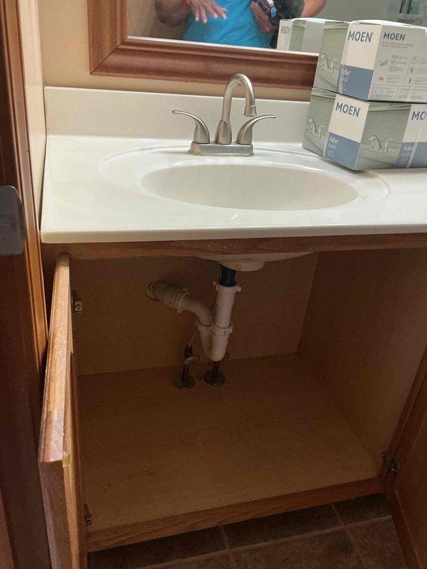 Successfully replaced three customer-supplied faucets in two bathrooms and installed a new customer-supplied toilet seat. Addressed slow drain issue in one bathroom that had been an ongoing concern. Removed items from under sink as requested and documented installation with photos showing completed work including brushed nickel two-handle faucet mounted on white vanity with integrated sink basin.