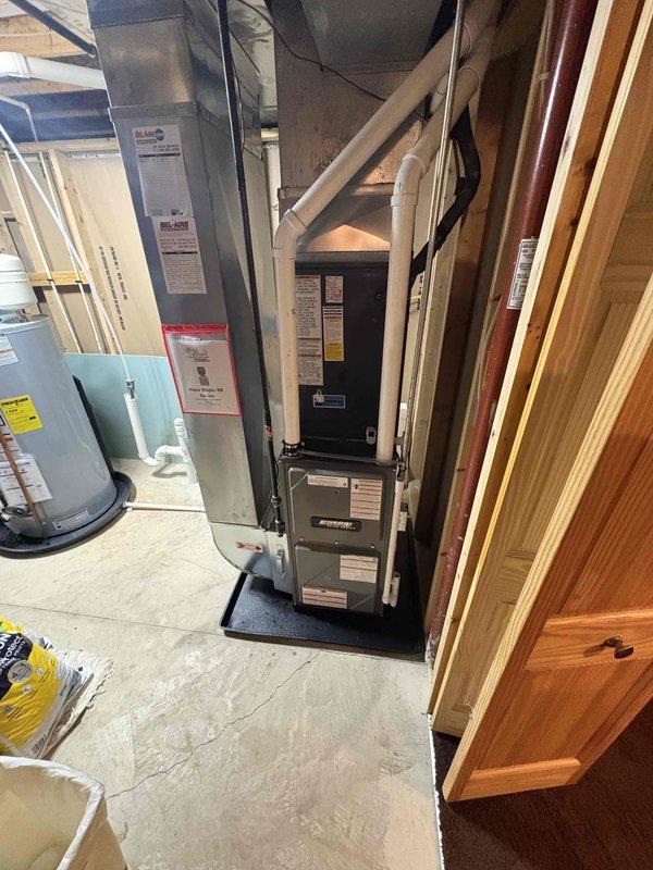 Completed full installation of new furnace and air conditioning system. Furnace unit was installed in basement utility area on platform base with proper venting via PVC piping and electrical connections to panel box. Outdoor condenser unit was positioned on concrete pad with rock bed for drainage, refrigerant lines were run and secured to exterior wall with proper line sets, and electrical conduit was installed. All ductwork connections were completed, system was charged, and full operational testing was performed to verify heating and cooling functionality.