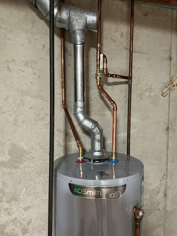Responded to water leak at residential water heater. Upon arrival, inspected AO Smith water heater and associated plumbing connections. Identified leak originating from pipe connection at top of unit near shut-off valves. Assessed copper piping, galvanized ductwork, and brass fittings for source of water intrusion. Tightened connection at leaking pipe junction and verified all hot and cold water line connections were secure. Tested system operation and confirmed leak was resolved with no further water discharge observed.