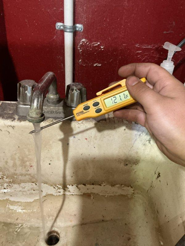 Responded to service call for 2017 Bradford water heater with inadequate hot water temperature despite pilot light functioning properly. Upon inspection, measured outlet temperatures at multiple fixtures throughout the residence. Kitchen sink registered 119°F and utility sink measured 121°F, both significantly below the recommended 120-140°F range for optimal domestic hot water usage. Verified pilot light operation and burner ignition. Adjusted temperature control setting on gas valve to increase water temperature output. Tested system operation through multiple heating cycles to ensure proper burner response and temperature recovery. Educated customer on proper temperature settings and monitoring procedures for future reference.
