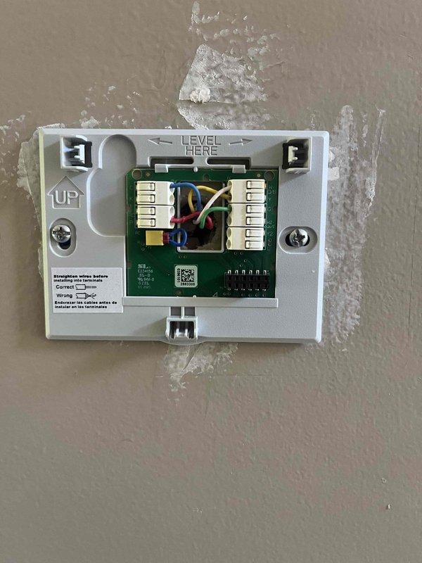 Responded to no-power condition on newly installed thermostat in manufactured home with 2011 cooling system. Upon arrival, found thermostat displaying no power and HVAC system completely non-operational following recent thermostat replacement. Removed thermostat from wall plate and inspected wiring connections at terminal board. Verified all low-voltage wires (R, C, Y, G) were properly seated in correct terminals on both thermostat and equipment. Checked for 24V power supply from transformer and confirmed adequate voltage present. Identified and corrected wiring issue that prevented proper power delivery to thermostat. Reinstalled thermostat on wall plate, verified level installation, and tested all system functions. Confirmed thermostat powered on successfully and system responded appropriately to heating and cooling calls. Documented installation with photos of wiring configuration and ductwork in attic space. System restored to full operational status.