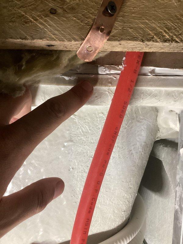 Responded to report of water leaking from upstairs into kitchen with concerns about mold and mildew development. Upon inspection, discovered significant ice and frost buildup on HVAC evaporator coil assembly, indicating a refrigerant or drainage issue rather than a traditional plumbing leak. The frozen coil was causing condensation to overflow and drip through ceiling into kitchen area below. Documented extensive frost accumulation on coil fins and metal surfaces, as well as plumbing connections and water heater components in affected area. Identified blocked condensate drain line as primary cause of water intrusion. Recommended immediate defrost of evaporator coil, clearing of condensate drain line, and inspection of drainage pan to prevent further water damage and potential mold growth.