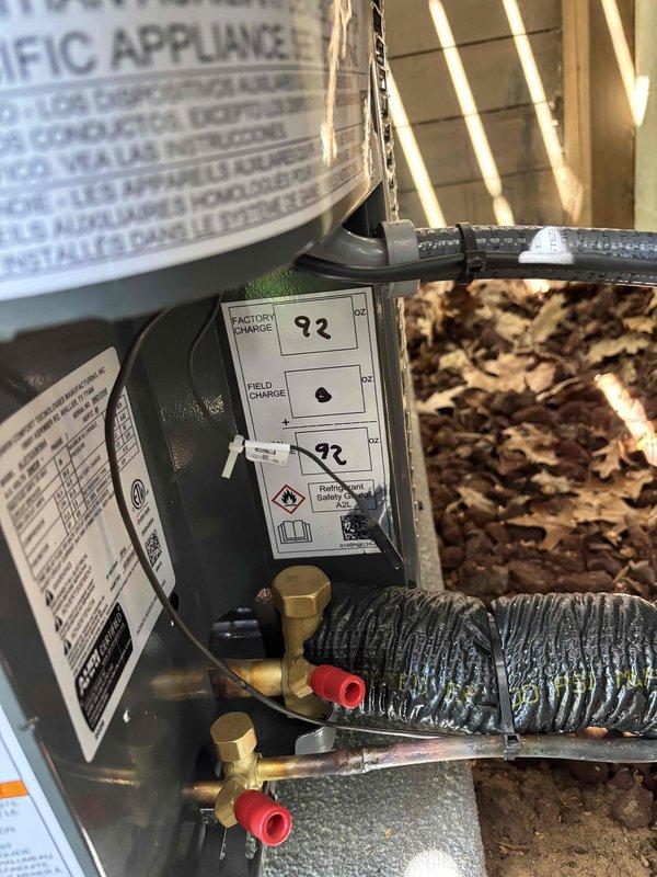 Completed full installation of new furnace and air conditioning system. Indoor furnace unit installed in crawl space with proper refrigerant line connections, factory charge verified at 93 oz, and all ports secured with protective caps. Outdoor condenser units positioned on concrete pad with refrigerant lines and electrical conduit properly routed between components. System installation verified and operational.