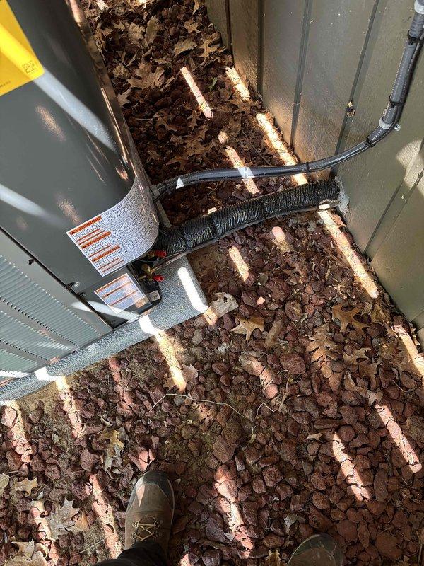 Completed full installation of new furnace and air conditioning system. Indoor furnace unit installed in crawl space with proper refrigerant line connections, factory charge verified at 93 oz, and all ports secured with protective caps. Outdoor condenser units positioned on concrete pad with refrigerant lines and electrical conduit properly routed between components. System installation verified and operational.