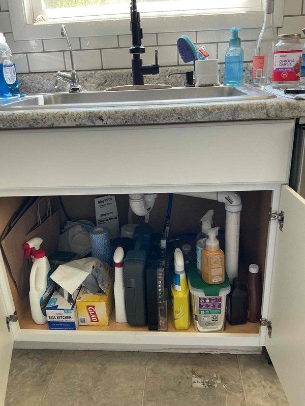 Responded to kitchen sink drain blockage that was not resolved by previous snaking attempts or chemical drain cleaner. Inspected under-sink plumbing configuration including garbage disposal and PVC drain lines. Accessed drain system from basement crawlspace and identified blockage in horizontal drain run between floor joists. Successfully cleared obstruction and restored proper drainage flow to kitchen sink.