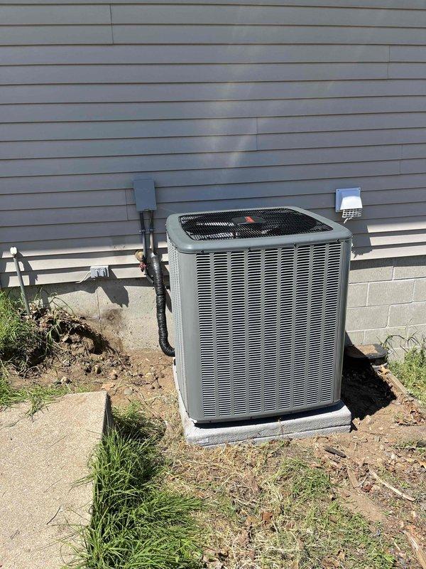 Completed full HVAC system replacement including indoor furnace unit and outdoor condensing unit. Installed new furnace in basement utility area with proper refrigerant line connections, condensate drainage via PVC piping, and electrical hookup through junction box. Mounted unit on drain pan with appropriate fittings for moisture management. Ran black insulated refrigerant lines from furnace to outdoor unit, ensuring proper routing and insulation throughout. Installed outdoor condensing unit on existing concrete pad adjacent to building foundation with refrigerant lines penetrating exterior wall and connecting to indoor system. Verified all electrical connections, refrigerant line integrity, and drainage systems operational. System tested and confirmed functioning properly upon completion.