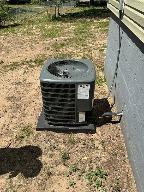 Responded to service call for humidifier hookup and AC unit evaluation. Upon arrival, assessed 6-year-old Goodman air conditioning condenser unit currently positioned on black plastic pad in residential yard. Confirmed unit is sitting at an improper angle, which can affect drainage and long-term performance. Discussed relocation options with customer to address leveling concerns and improve overall system positioning. Documented current installation conditions through photographs showing unit placement on uneven ground with displaced concrete support blocks nearby. Provided recommendations for proper leveling and potential repositioning of outdoor condenser unit to ensure optimal operation and longevity.