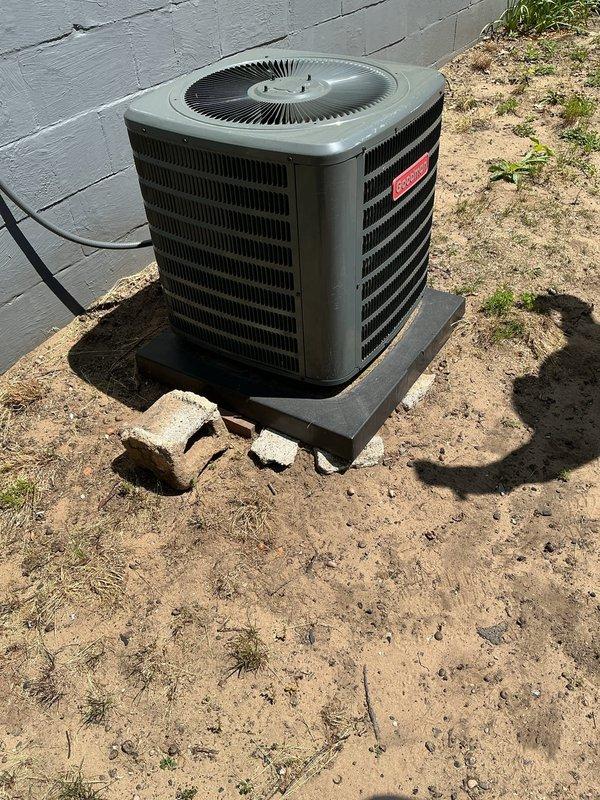 Responded to service call for humidifier hookup and AC unit evaluation. Upon arrival, assessed 6-year-old Goodman air conditioning condenser unit currently positioned on black plastic pad in residential yard. Confirmed unit is sitting at an improper angle, which can affect drainage and long-term performance. Discussed relocation options with customer to address leveling concerns and improve overall system positioning. Documented current installation conditions through photographs showing unit placement on uneven ground with displaced concrete support blocks nearby. Provided recommendations for proper leveling and potential repositioning of outdoor condenser unit to ensure optimal operation and longevity.