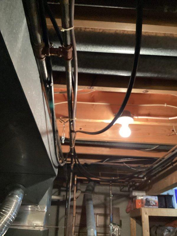 Responded to emergency gas leak call with whole home system shut down. Upon arrival, inspected 5-year-old heating system and associated gas lines in basement utility area. Located and assessed small gas leak in vicinity of furnace and exposed piping system. Verified system shutdown for safety, investigated leak source among copper pipes and gas supply lines visible in mechanical space. Documented conditions with photographs showing exposed ceiling infrastructure, ductwork, refrigerant lines, and furnace installation. Addressed immediate safety concerns and restored safe operation of heating system.
