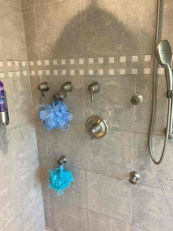 Responded to multi-function shower system requiring cartridge replacement after accidental damage during previous service. Successfully removed and replaced damaged cartridge in shower control valve. Tested all shower fixtures including wall-mounted body sprays, handheld shower head, and temperature/flow controls to verify proper operation. System restored to full functionality with no leaks detected. Work completed in approximately 2 hours.