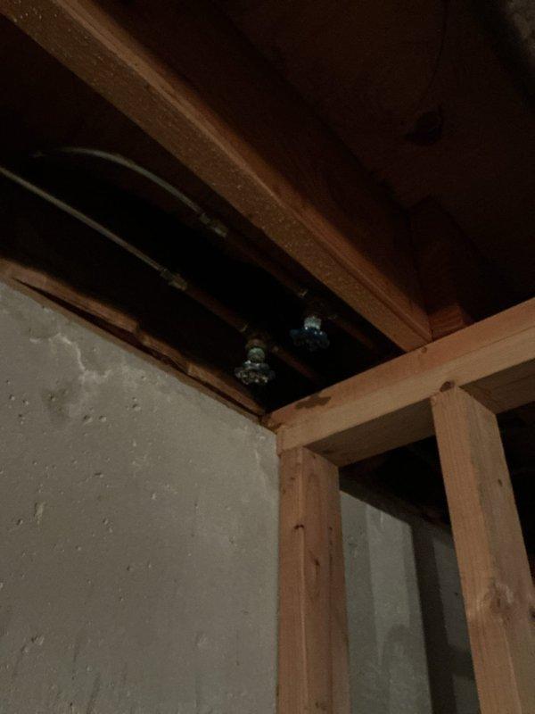 Responded to plumbing leak service call for leaking valve in garage area connected to downstairs plumbing system. Inspected and addressed leak at valve junction between lower level and garage, examining exposed piping and connections in ceiling/wall cavity. Also performed requested inspection of pressure switch and conducted brief evaluation of kitchen sink plumbing as part of comprehensive service visit.