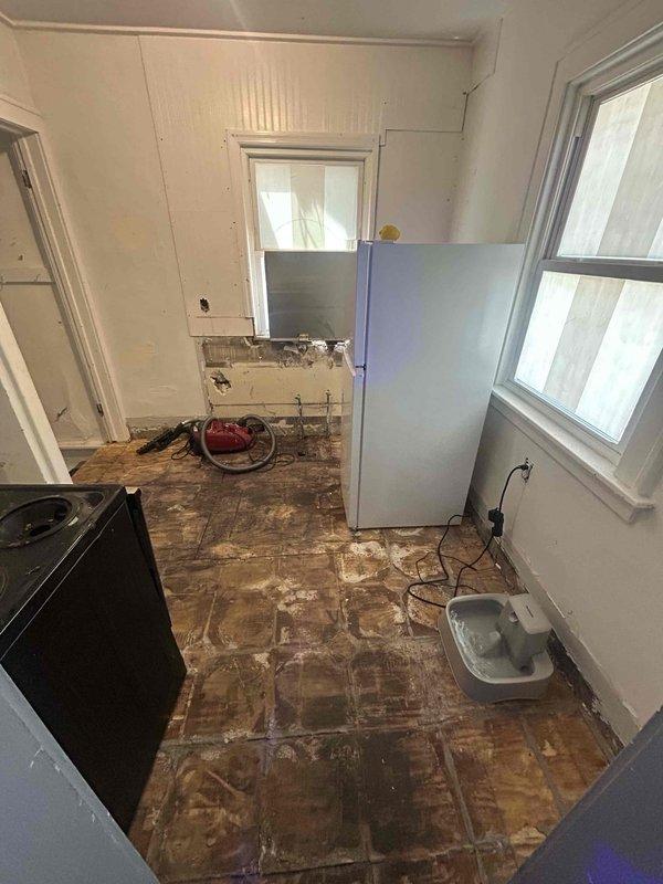 Responded to no-cool service call for air conditioning system over 5 years old that would not turn on. Upon arrival, found property in significant state of disrepair with extensive floor damage and renovation work in progress. Assessed HVAC system accessibility and operational status in challenging work environment. Documented property conditions and equipment location with photographic evidence for service records.