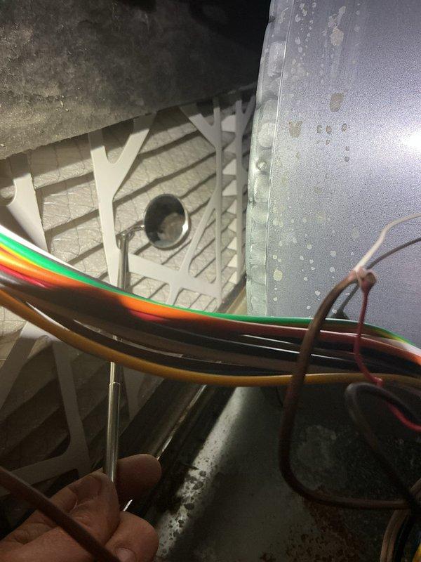 # NOISE - Indoor AC Unit Making Loud Noise

Responded to service call for loud noise originating from indoor air handler unit in utility room. System was still providing adequate cooling despite noise complaint. Upon arrival, performed visual and auditory inspection of 4-year-old EnergiAir air handler unit.

Accessed interior components of air handler to identify noise source. Inspection revealed significant rust and corrosion on electrical terminal mounting surfaces and metal brackets within the unit. Corrosion was extensive, showing reddish-brown discoloration, flaking, and pitting indicative of prolonged moisture exposure. Despite deterioration of mounting hardware, electrical connections remained secure with multiple colored wires properly terminated at junction points.

Examined blower assembly, motor mounts, and mechanical components for loose hardware, debris, or failing bearings that could generate operational noise. Checked electrical wiring harness including rainbow-striped c
