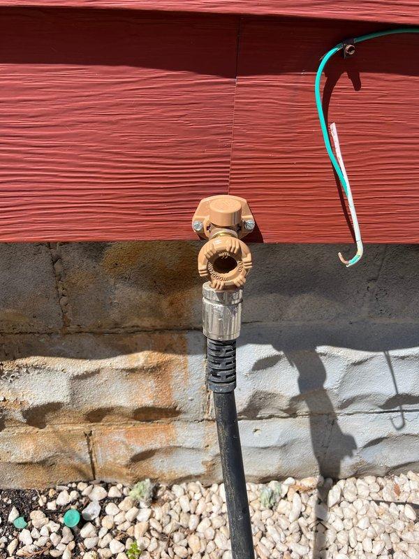 Replaced exterior hose bib with new frost-free sillcock assembly, including shutoff valve and proper drainage configuration to prevent future water damage and foundation staining. Installed new brass valve with wheel handle and connected existing garden hose to verify proper operation and flow.