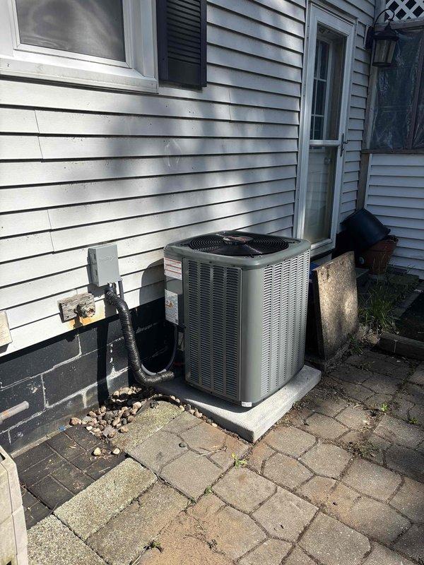 Completed full HVAC system replacement including outdoor condensing unit and indoor air handler. Installed new condenser on existing concrete pad with proper electrical disconnect and refrigerant line connections. Mounted air handler in attic space with new ductwork connections, copper refrigerant lines, and PVC condensate drainage system properly secured within wooden framing structure.