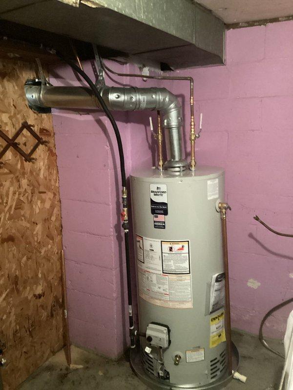 Installed a 40-gallon natural gas water heater with proper venting including B-vent connection to both the furnace and water heater. Replaced existing copper gas line with black pipe from the main supply to the water heater to meet current code requirements. Installed a 5-inch chimney liner to ensure safe exhaust ventilation for the system.