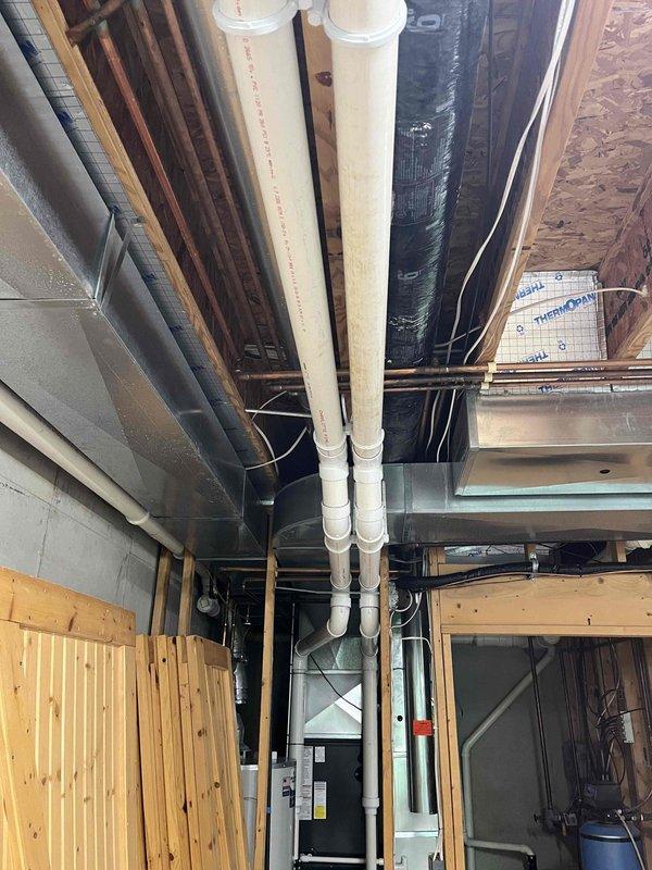 Conducted a no-charge indoor air quality assessment and documentation of existing HVAC system and mechanical equipment. Photographed and evaluated the mechanical room installation, including Bradford White water heater, furnace/air handler unit with intake and exhaust PVC venting, and associated ductwork systems. Inspected vertical drain/vent lines, insulated ductwork, and overall equipment configuration in the basement mechanical space. Provided visual documentation of current system layout and equipment conditions for customer records and future service reference.