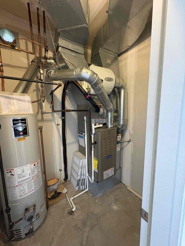 Completed full HVAC system installation including new Carrier furnace and air conditioning unit in residential mechanical room. Installed all necessary ductwork, PVC condensate lines, electrical connections, and integrated AprilAire humidifier system. Verified proper clearances around water heater, tested all safety controls, and confirmed system operation meets manufacturer specifications.