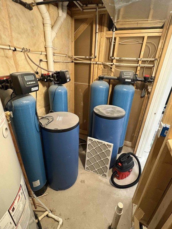 Responded to service call for 9-year-old air conditioning unit running but not producing cold air. Upon arrival, conducted diagnostic assessment of cooling system. Documented existing mechanical equipment in utility area including water heater and water treatment systems for reference. System evaluation completed and photographic documentation taken of equipment specifications and installation environment to support service records and determine appropriate repair recommendations.