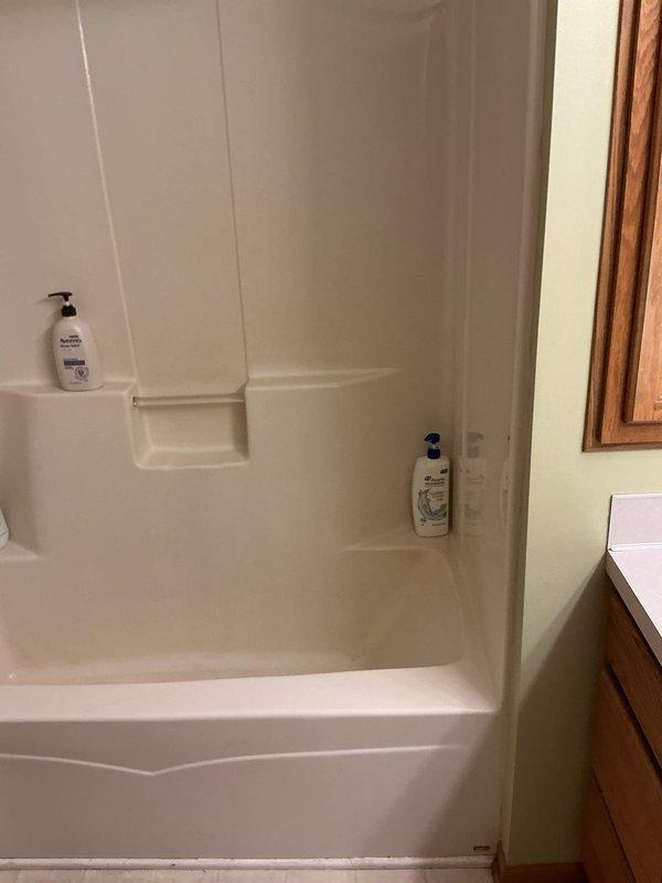 Conducted comprehensive plumbing project assessment for bathroom remodel, documenting existing fiberglass tub/shower combination unit with integrated soap shelf and wooden vanity cabinet. Photographed current bathroom configuration and adjacent closet space to develop accurate scope of work for proposed plumbing modifications and fixture replacements.