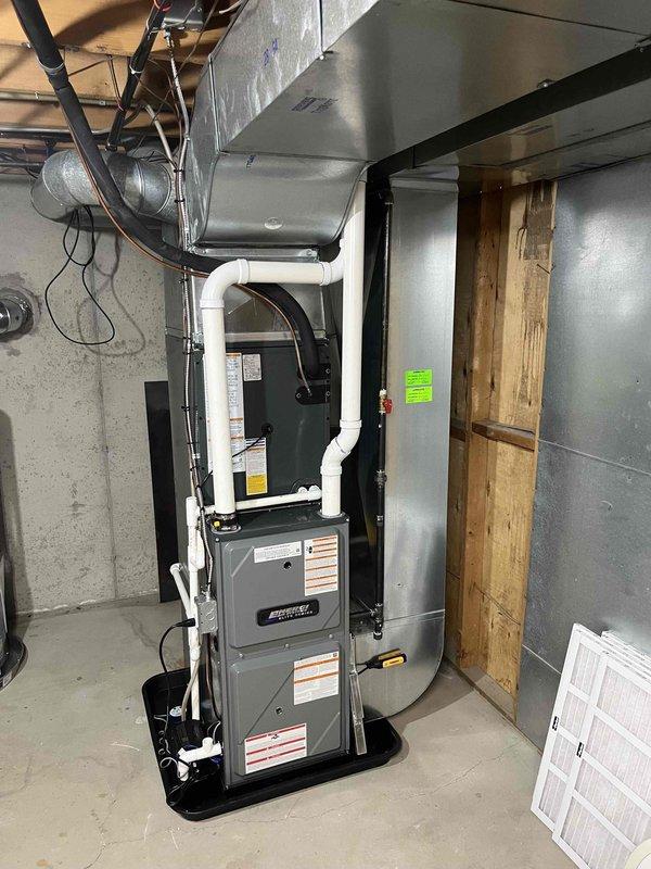 Completed full HVAC system installation including new furnace and air conditioning condenser unit. Interior furnace installed in basement on platform base with proper PVC venting routed upward, connected to ductwork with reflective insulation, and integrated with air handler component. Exterior condenser unit positioned on concrete pad at side of residence with proper clearances maintained, all electrical connections completed, and system tested for proper operation.