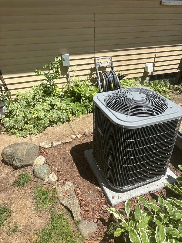 Completed full HVAC system installation including new furnace and air conditioning condenser unit. Furnace installed in interior utility space with proper ductwork connections, metallic supply plenum, and digital thermostat control panel mounted on unit. AC condenser positioned on concrete pad against exterior wall with appropriate clearances, connected to indoor system via refrigerant lines and electrical service. All ductwork properly sealed and secured, condensate drainage configured, and system tested for proper operation. Unit confirmed operational with correct airflow, temperature differential, and refrigerant charge verified within manufacturer specifications.