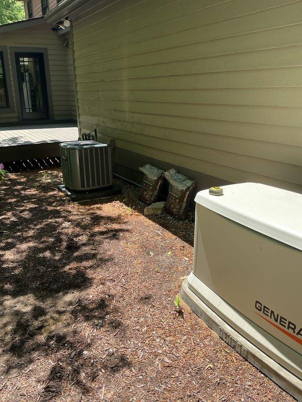 Relocated Generac standby generator unit to new position along side of residence per client request. Generator was disconnected, moved from original location, and reinstalled on prepared gravel pad with proper clearances from structure and adjacent HVAC equipment. Unit was reconnected, tested for proper operation, and site was left clean and organized with landscaping materials staged for completion of surrounding area.